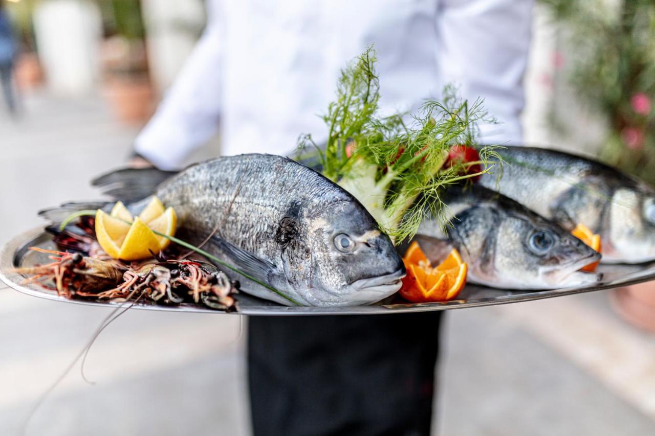 Lighthouse Golf & Spa Hotel Balchik Luaran gambar A waiter holding a platter of fish